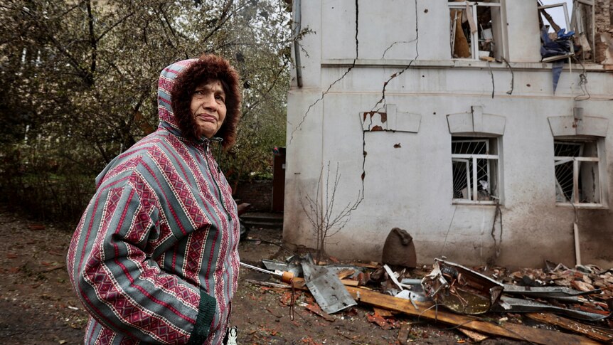 A local resident stands next to a museum building, heavily damaged by a Russian missile strike.