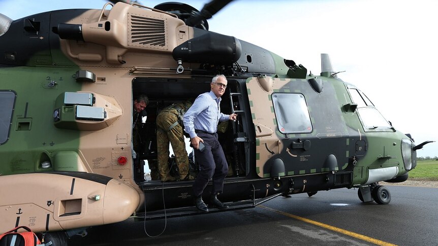 Australian Prime Minister Malcolm Turnbull jumps out of an Australian Defence Force helicopter in Bowen.