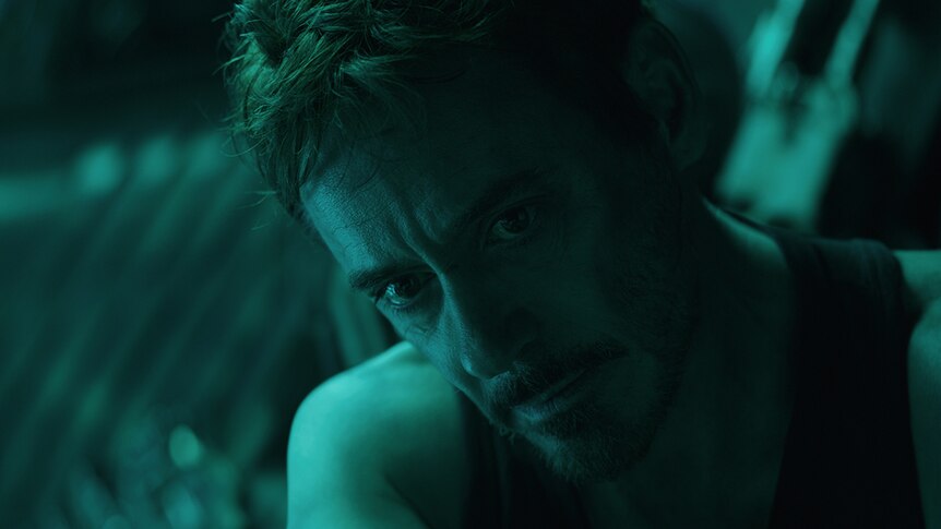 Colour close-up still of Robert Downey Jr.'s face in half shadow in 2019 film Avengers: Endgame.