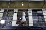 A handcuffed man walks down a hallway on death row.