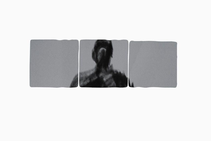 A silhouette of a man's head and shoulders can be seen in three squares which are forming a window.