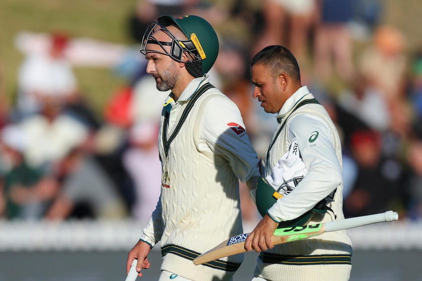 Batters Nathan Lyon and Usman Khawaja leave the field after a day of play in a Test between Australia and New Zealand.