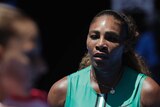 Serena Williams walks toward Karolina Pliskova, blurred in the foreground, during their Australian Open tennis match.