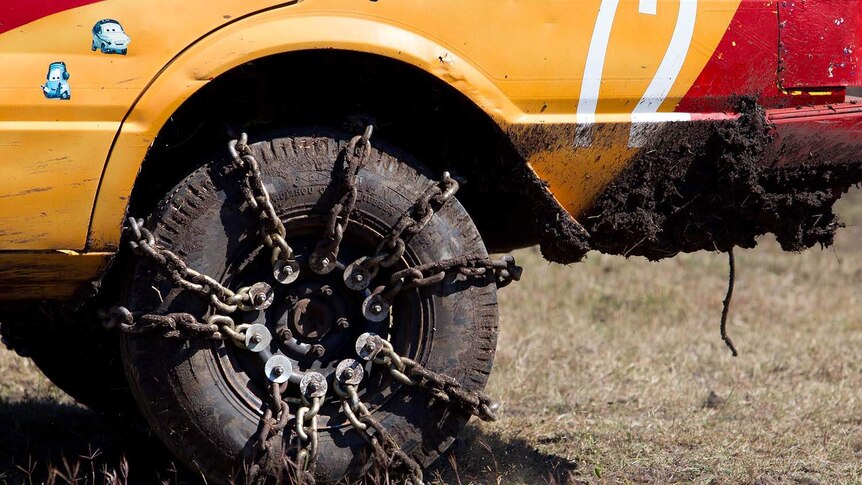 Chains are fastened to a wheel on a car at Kabra mud races