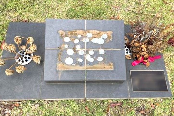 A picture of a stone grave with a plaque missing.
