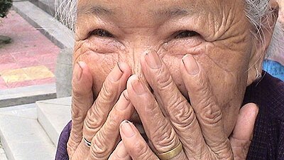 Old woman laughing and embarrassed/ stock.xchng