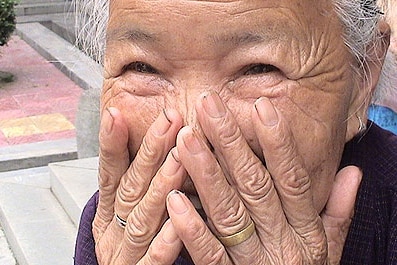 Old woman laughing and embarrassed/ stock.xchng