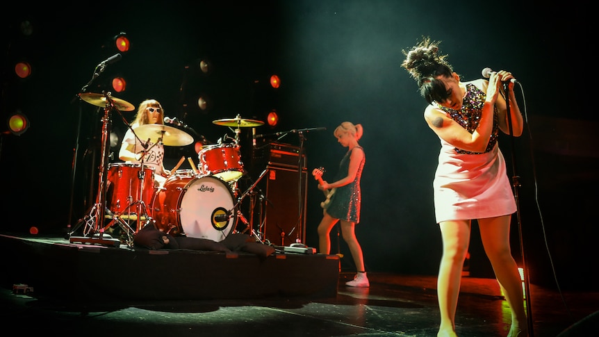 a photo of 3 female musicians in bikini kill on stage