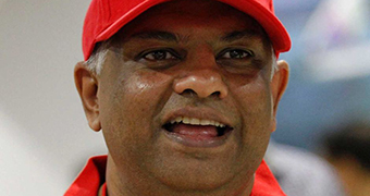 A tight head shot of AirAsia boss Tony Fernandes wearing a red hat.