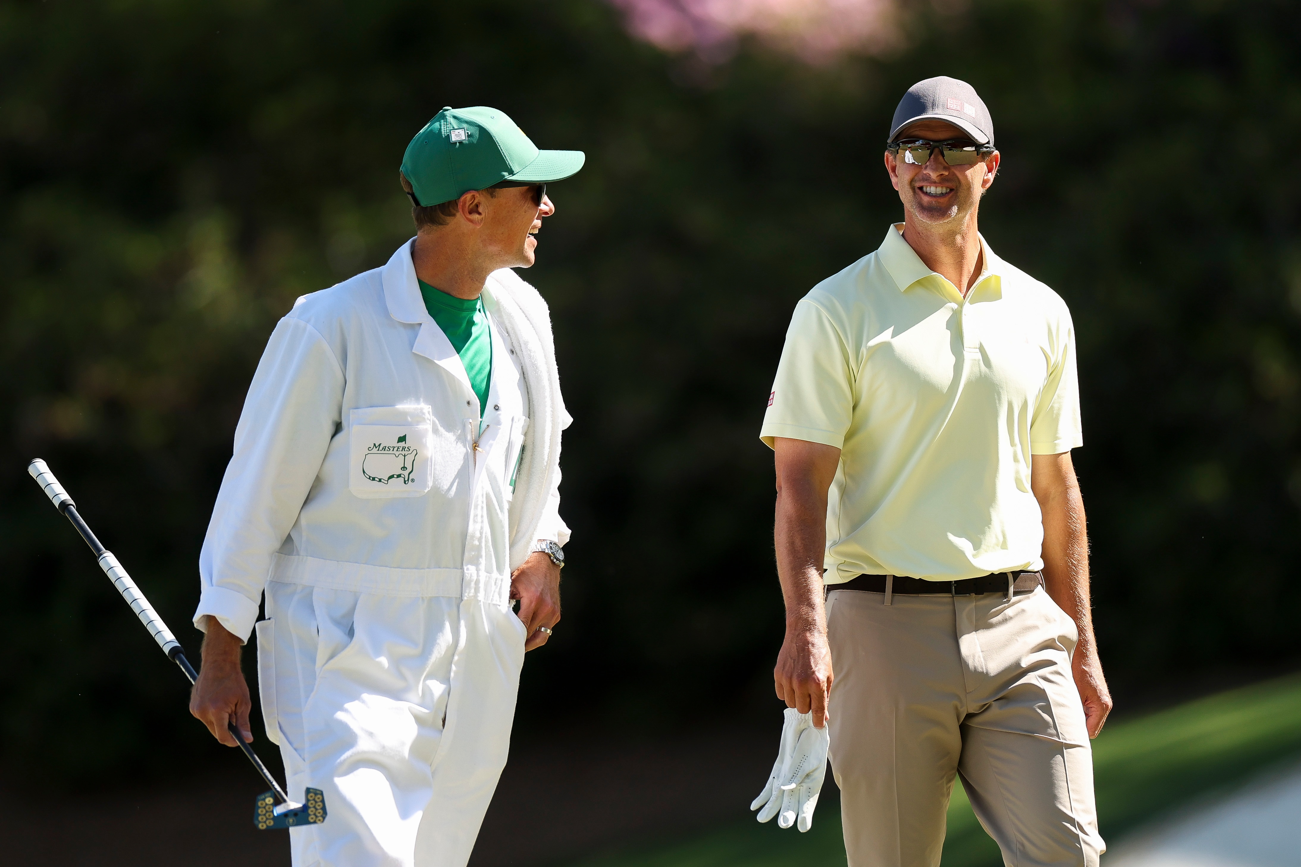 Adam Scott and his caddy smile as they walk the Masters course.