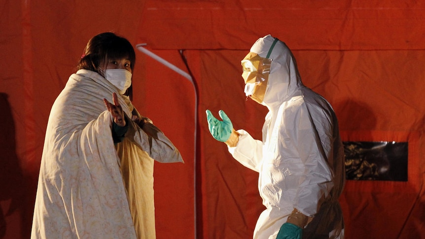 Official in protective gear talks to a woman