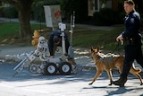 An officer from the bomb squad walks a dog.