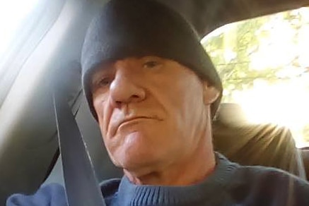 Headshot of a man in a vehicle wearing a beanie.