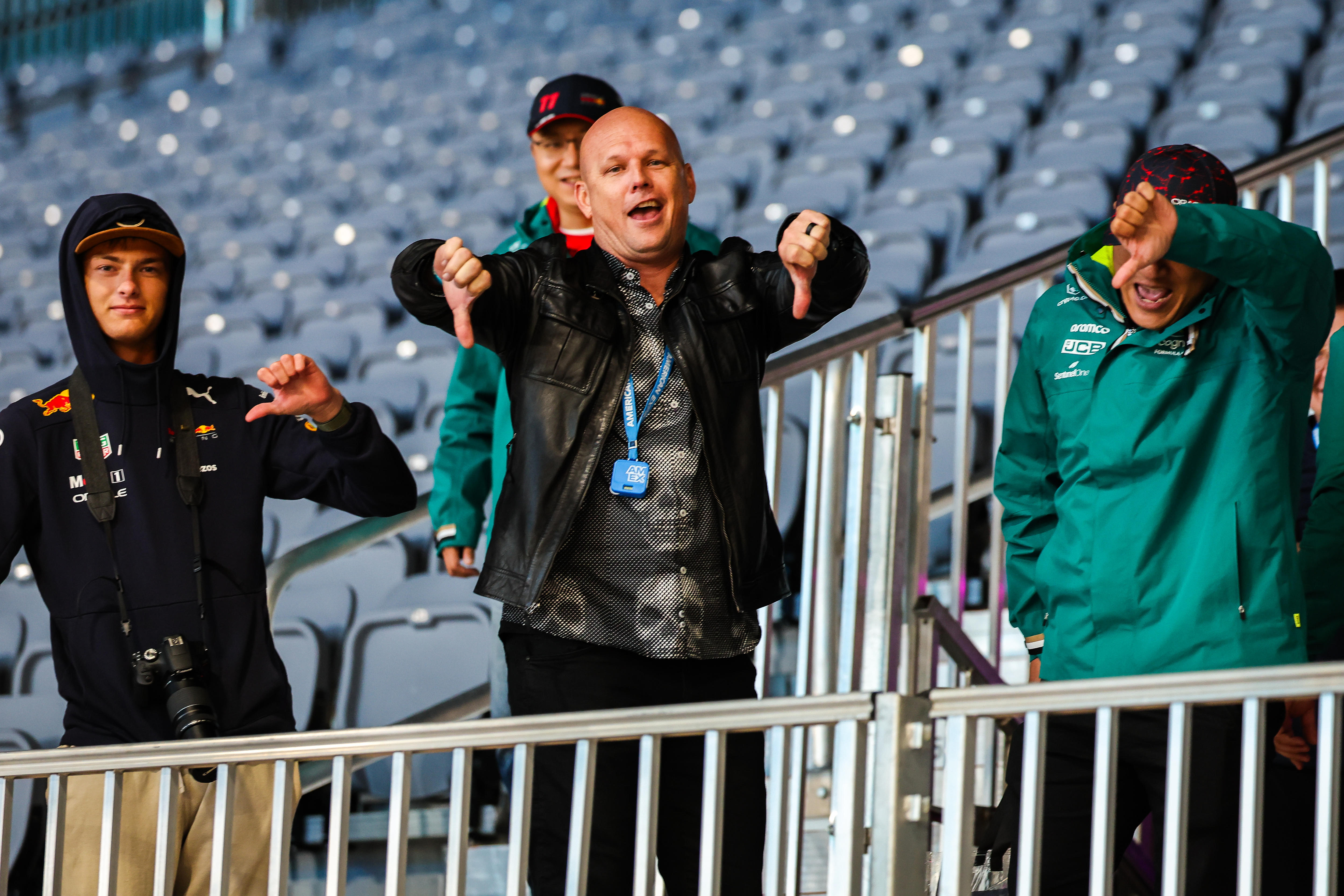Fans in a mostly empty grandstand, have their thumbs down in disapproval