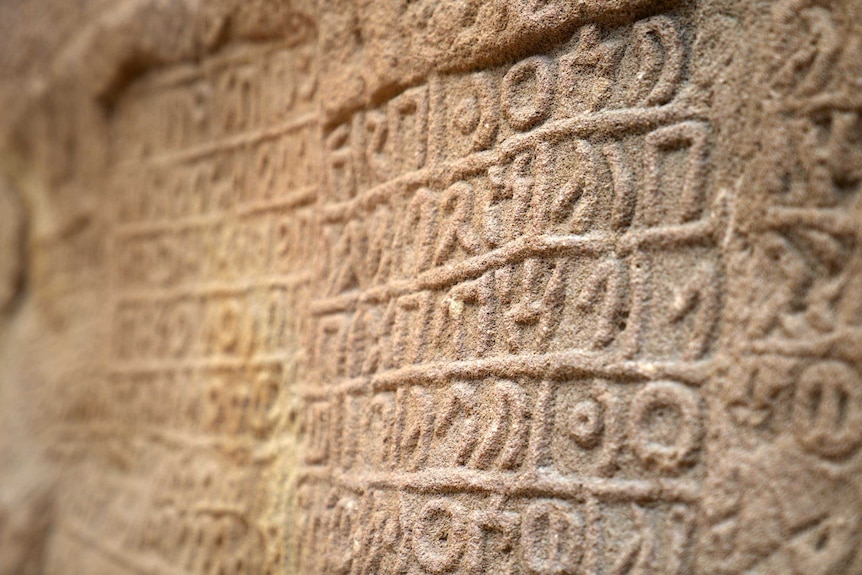 A rock with ancient writing carved into it.