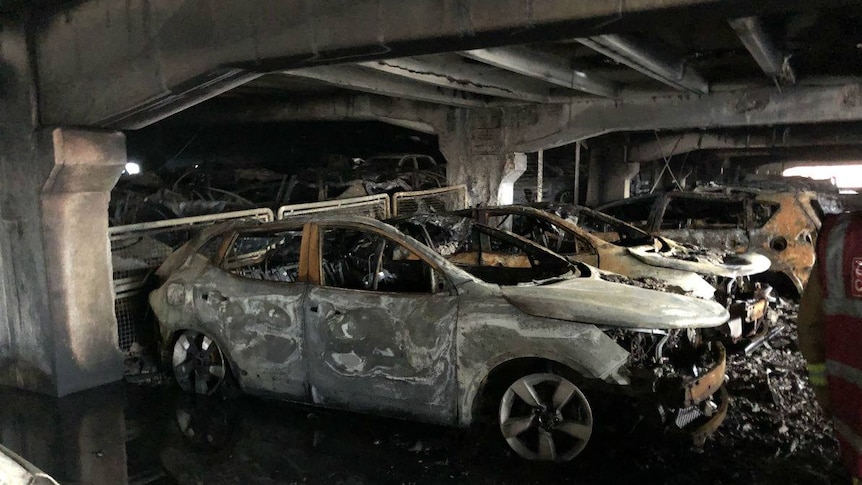 Burnt out cars inside a severely fire damaged car park