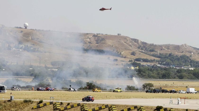 Emergency vehicles and helicopters surround the area where a plane skidded off the runway