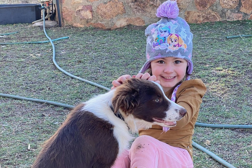 Lottie Taylor, 4, with her dog at her grandmother Marilyn Simpson's place at Windorah.