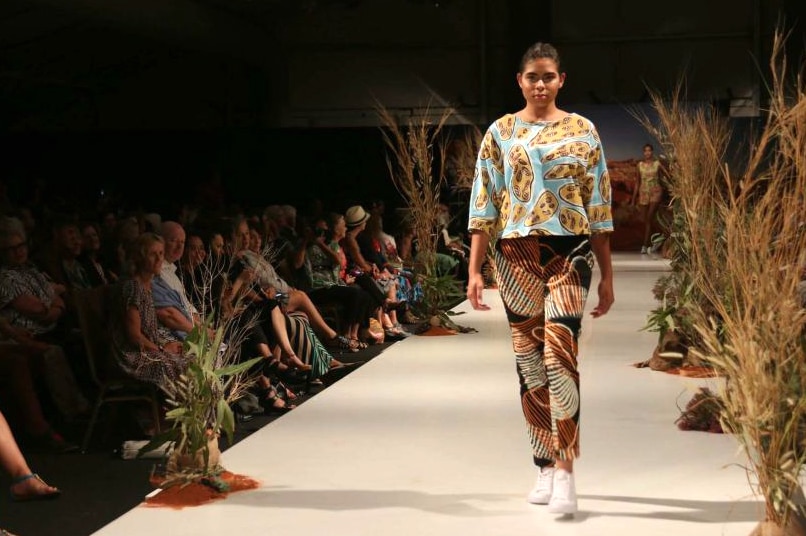 Girl walking at an Indigenous fashion show.