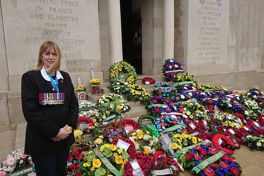 Kerri Morley stands in front of wreaths