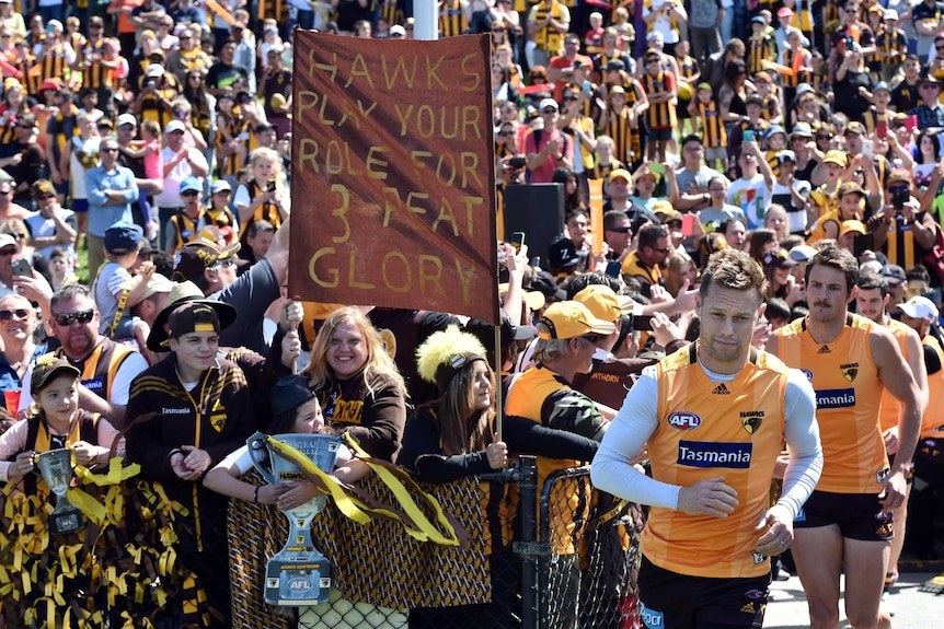 Sam Mitchell is cheered by fans before Hawthorn training