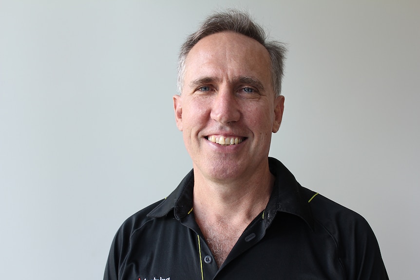 Steve manning standing in front of a white wall.