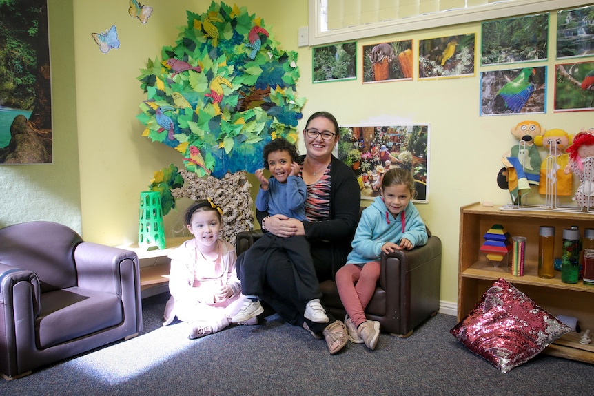 Amanda Bain sits in the local preschool with kids surrounding her.