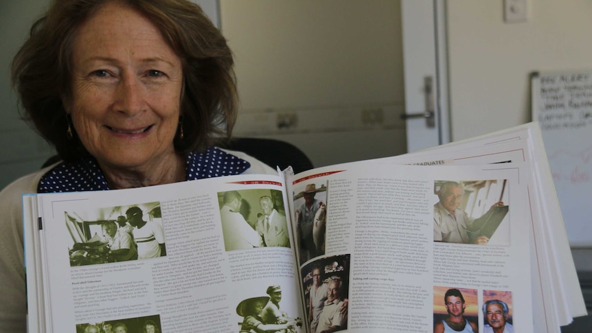 Helen Haritos holds a book that profiles her father George.