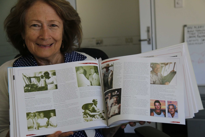 Helen Haritos holds a book that profiles her father George.