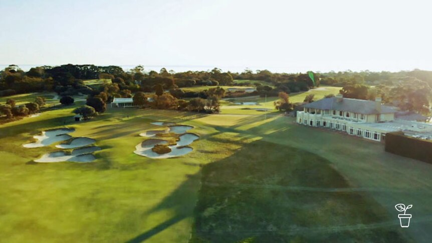 Aerial image of golf course with club house and sand bunkers