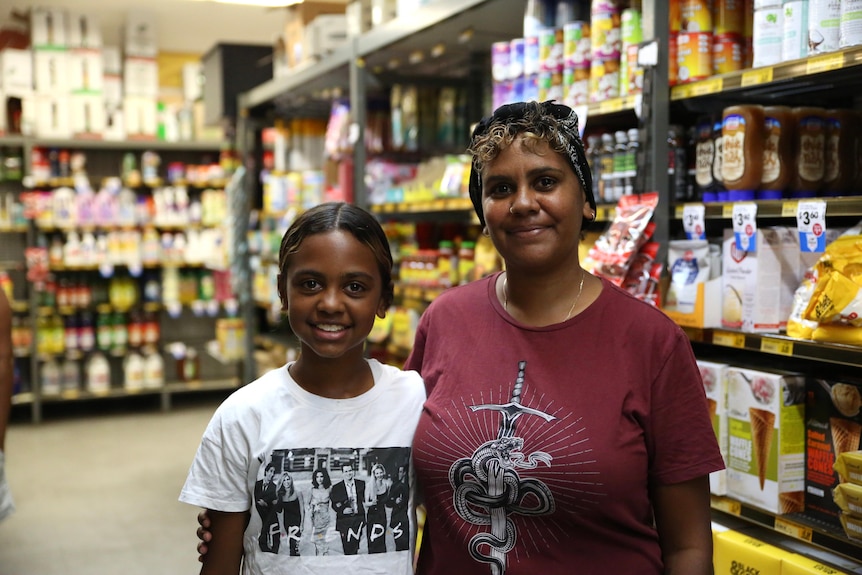 Una madre y una hija se paran en una tienda de comestibles