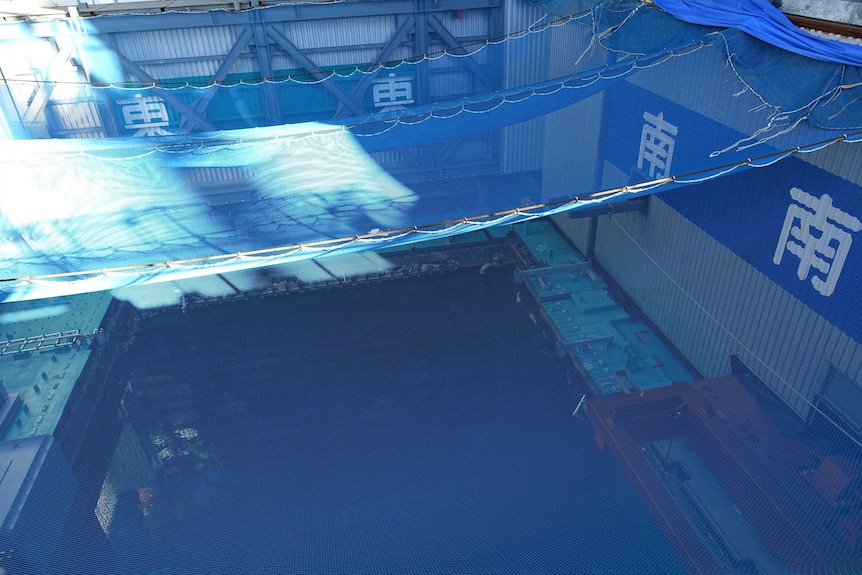 A blue pool with a net above it.