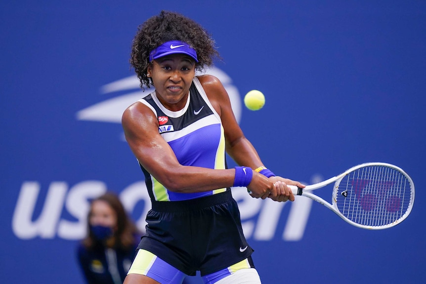 A tennis player eyes the ball as she brings the racquet back to hit a backhand at the US Open.