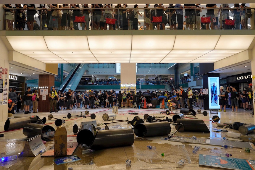 Protesters pour cooking oil and scatter debris to block the entrance to a subway station in Hong Kong, after police arrive.