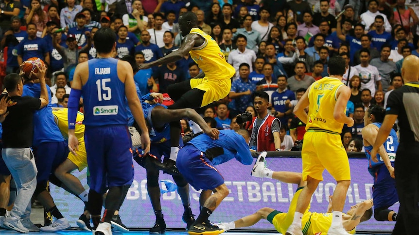 Australia's Thon Maker leaps onto a Filipino player in a brawl