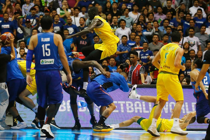 Australia's Thon Maker leaps onto a Filipino player in a brawl