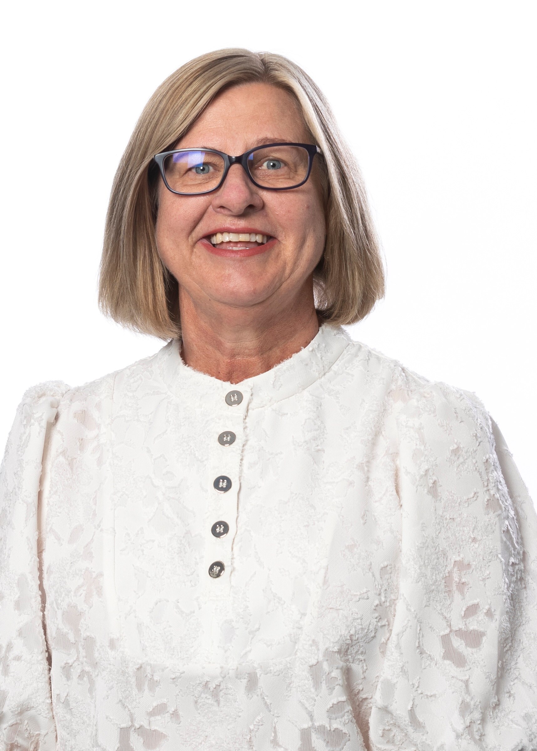 A woman with blonde hair and black glasses smiling for a portrait photo. 