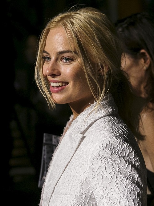 A close up of Margot Robbie smiling.