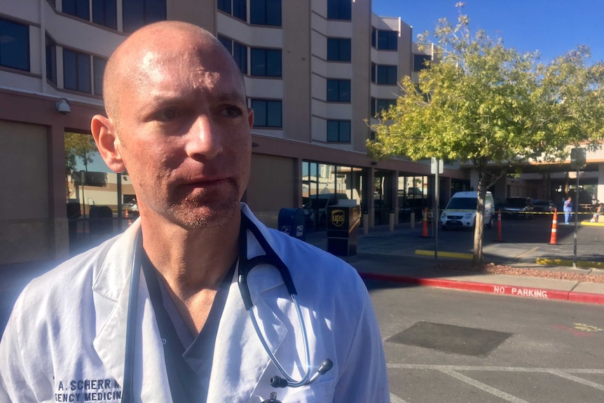 Dr Scott Scherr looks distressed and tired as he stands outside the hospital where many of the victims came through.