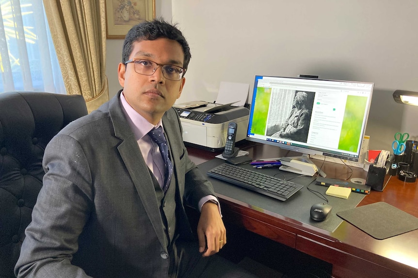 Psychiatrist Doctor Neil Jeyasingam sits at his desk in his practice.