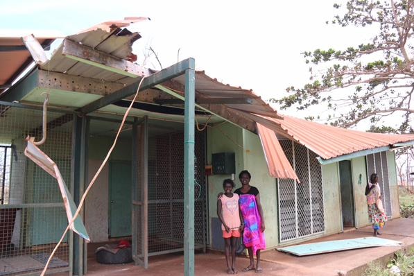 Galiwinku women stand beneath a house damaged by Cyclone Lam, on Saturday February 21, 2015.