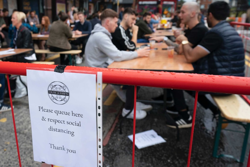 People sit outside drinking beer