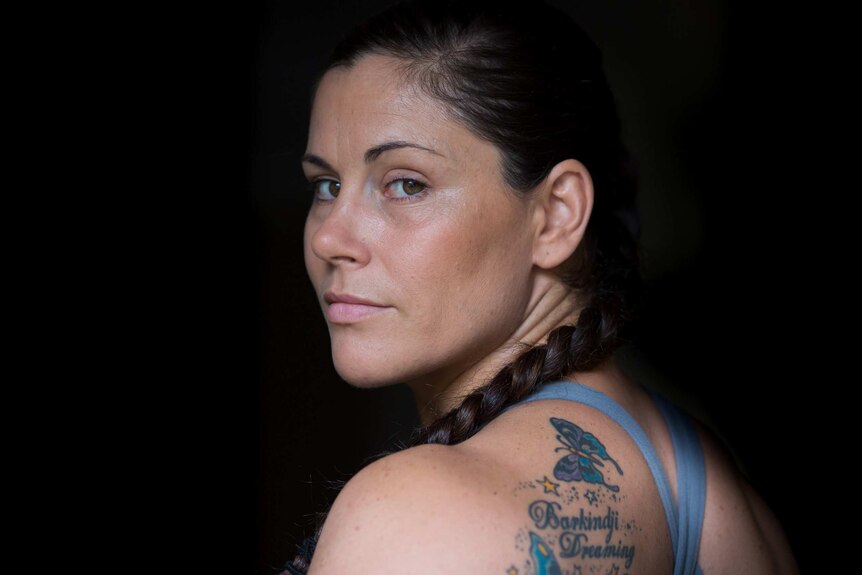 Close-up of jiu jitsu champion Shantelle Thompson looking into the camera, showing a shoulder tattoo.