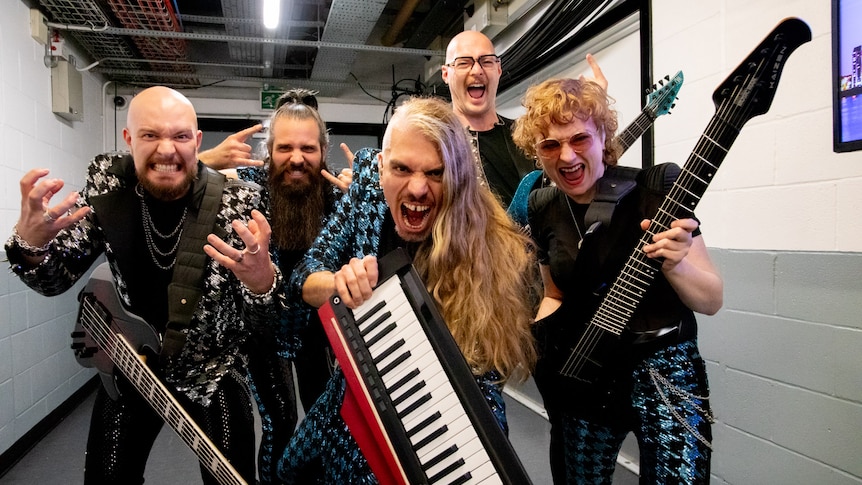 An Australian progressive metal group pose for the camera in a corridor backstage at the venue for the Eurovision Song Contest.