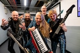 An Australian progressive metal group pose for the camera in a corridor backstage at the venue for the Eurovision Song Contest.