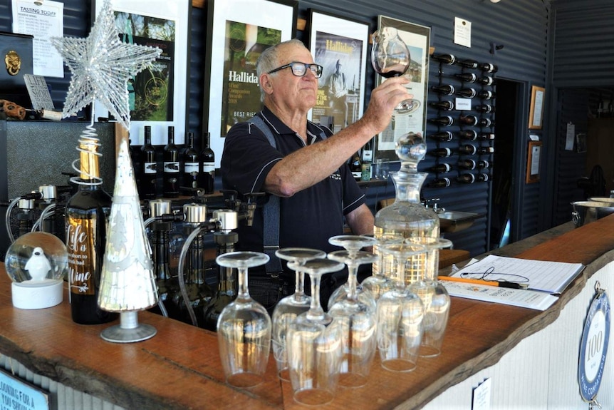 A man tastes wine in his winery.