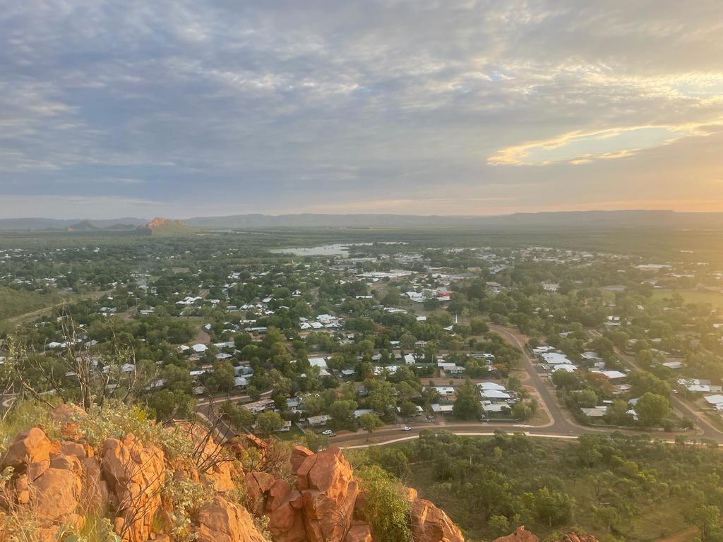 an aerial view of a town with orange hills and a river