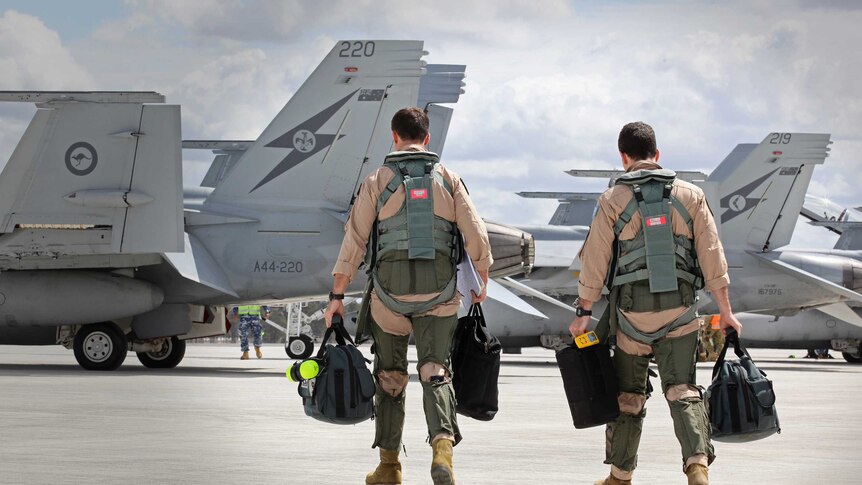 F/A-18F Super Hornet aircrew head to their aircraft in preparation for departure to the Middle East