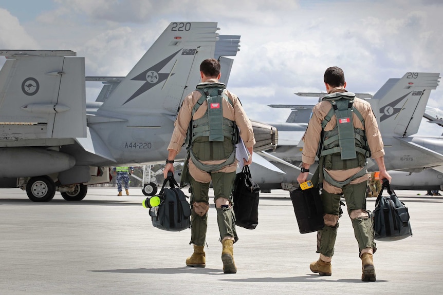 F/A-18F Super Hornet aircrew head to their aircraft in preparation for departure to the Middle East
