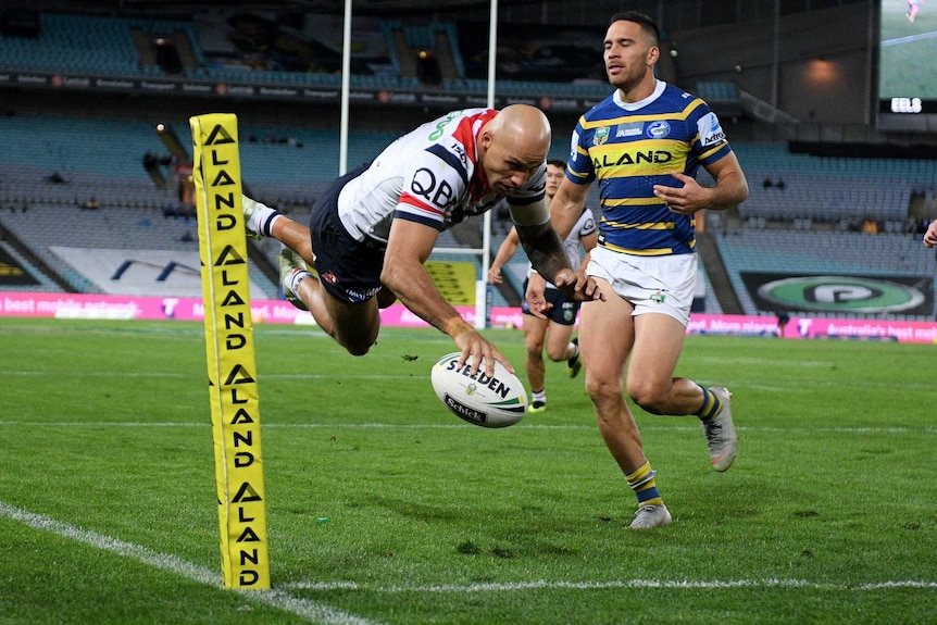 Blake Ferguson in mid-air as he plants the ball down in the corner for a Roosters try against the Eels.